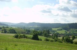 Blick von Fichtenberg nach Mittelrot in Richtung Gaildorf und Limpurger Land. Saftige Wiesen, grüne Berge, blauer Wolkenhimmel.